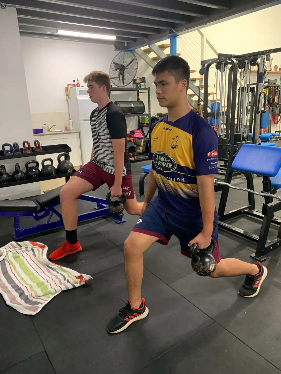 Junior athletes performing kettlebell lunges at ZeroW South Gold Coast